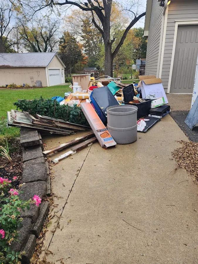 Dumpster being loaded with debris for 12 Yard Dumpster Rental in Whitefish